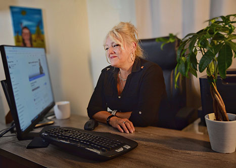 Photo of Nathalie Mallette at her desk looking at her computer screen.
